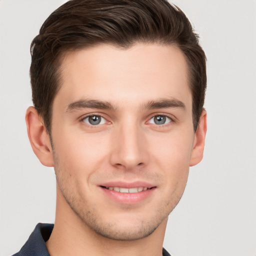 Joyful white young-adult male with short  brown hair and grey eyes