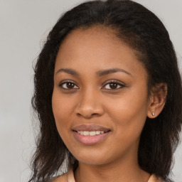 Joyful black young-adult female with long  brown hair and brown eyes