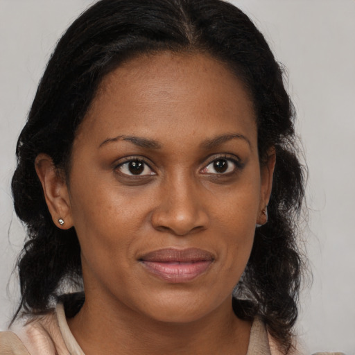 Joyful black adult female with medium  brown hair and brown eyes