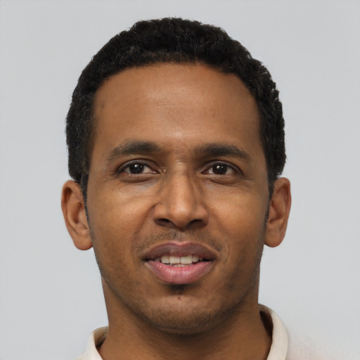 Joyful black young-adult male with short  black hair and brown eyes