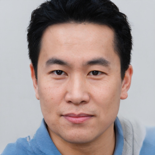 Joyful asian young-adult male with short  black hair and brown eyes