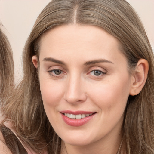 Joyful white young-adult female with long  brown hair and grey eyes