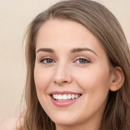 Joyful white young-adult female with long  brown hair and grey eyes