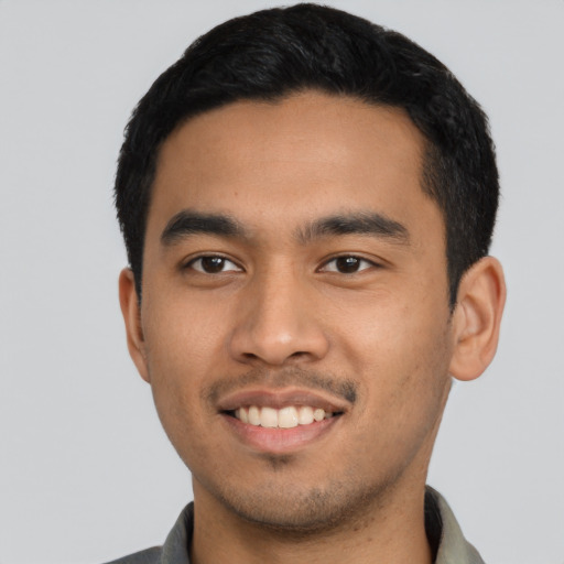 Joyful latino young-adult male with short  black hair and brown eyes