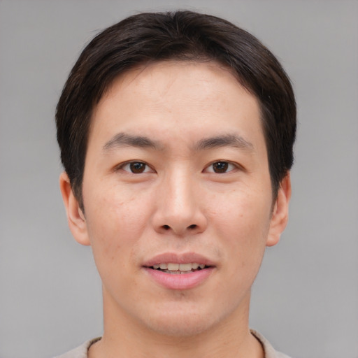 Joyful asian young-adult male with short  brown hair and brown eyes