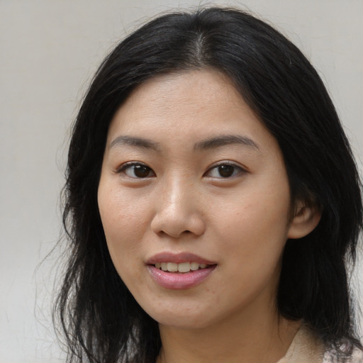 Joyful asian young-adult female with long  black hair and brown eyes