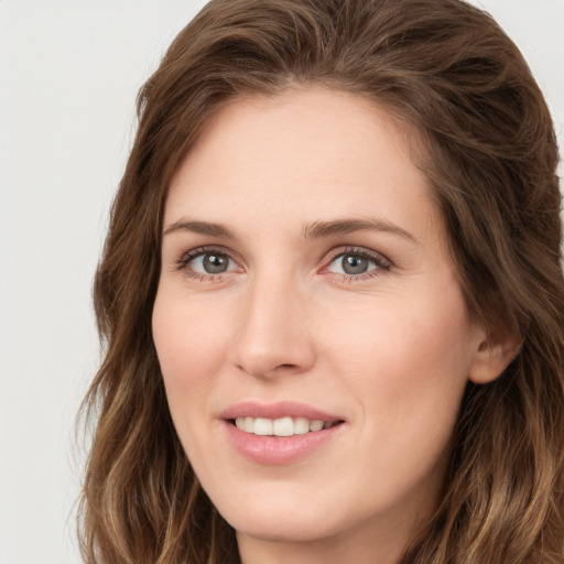 Joyful white young-adult female with long  brown hair and green eyes