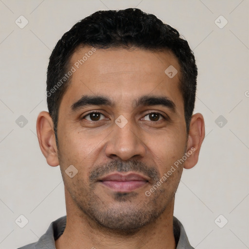 Joyful latino young-adult male with short  black hair and brown eyes