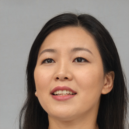 Joyful asian young-adult female with long  brown hair and brown eyes
