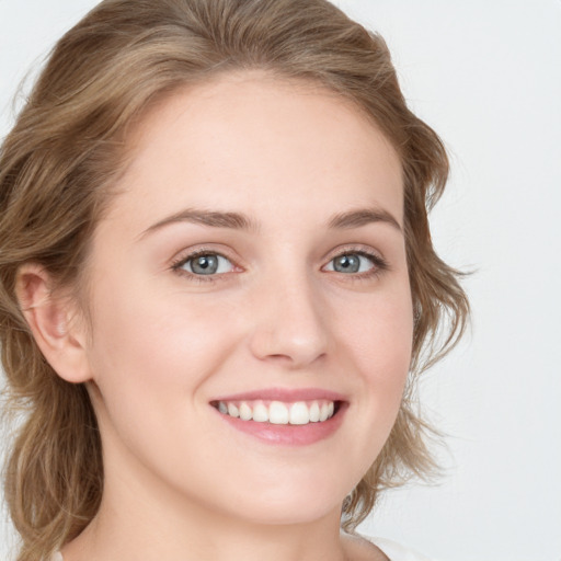 Joyful white young-adult female with medium  brown hair and blue eyes