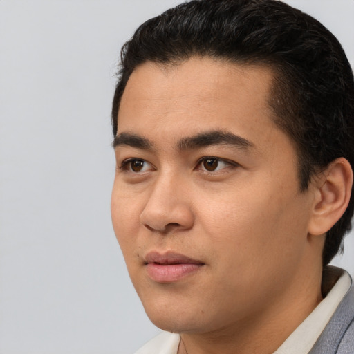 Joyful latino young-adult male with short  black hair and brown eyes