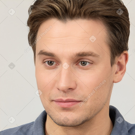 Joyful white young-adult male with short  brown hair and grey eyes