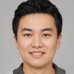 Joyful asian young-adult male with short  brown hair and brown eyes