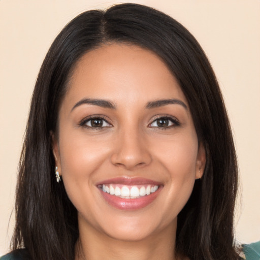 Joyful latino young-adult female with long  brown hair and brown eyes