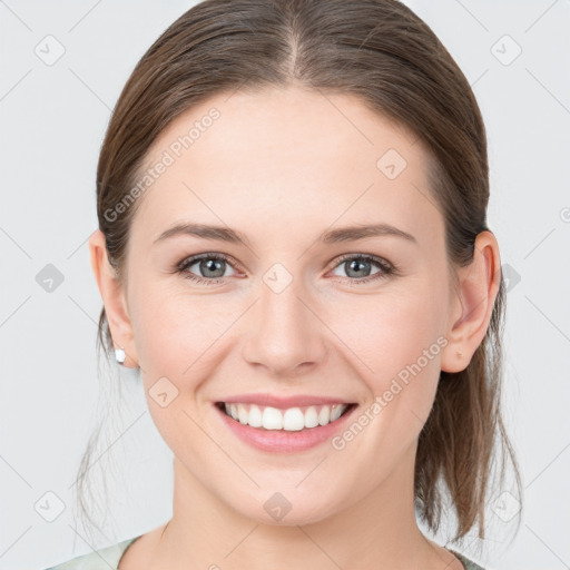 Joyful white young-adult female with medium  brown hair and grey eyes