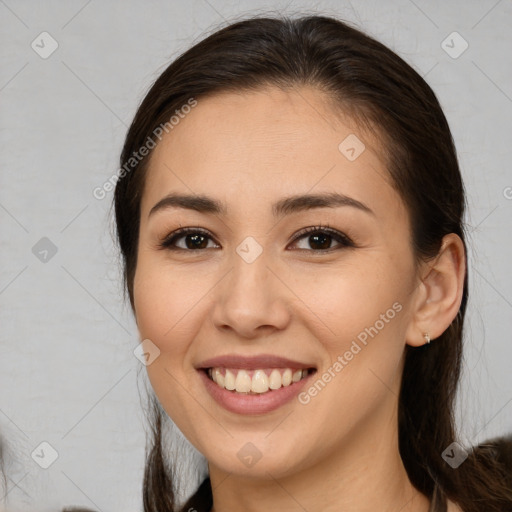 Joyful white young-adult female with long  brown hair and brown eyes