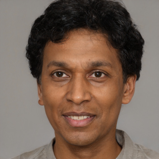 Joyful latino adult male with short  brown hair and brown eyes