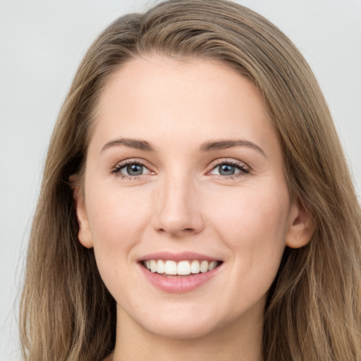 Joyful white young-adult female with long  brown hair and grey eyes