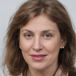 Joyful white adult female with medium  brown hair and grey eyes