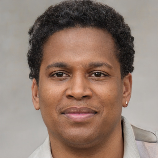Joyful black young-adult male with short  brown hair and brown eyes