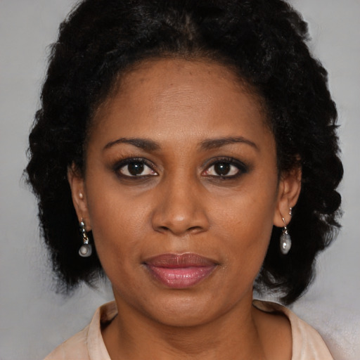 Joyful black adult female with medium  brown hair and brown eyes