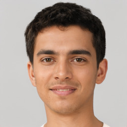 Joyful latino young-adult male with short  brown hair and brown eyes