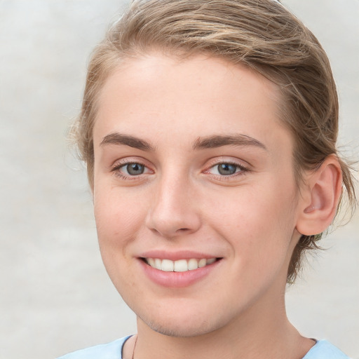 Joyful white young-adult female with medium  brown hair and blue eyes