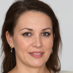 Joyful white adult female with long  brown hair and brown eyes