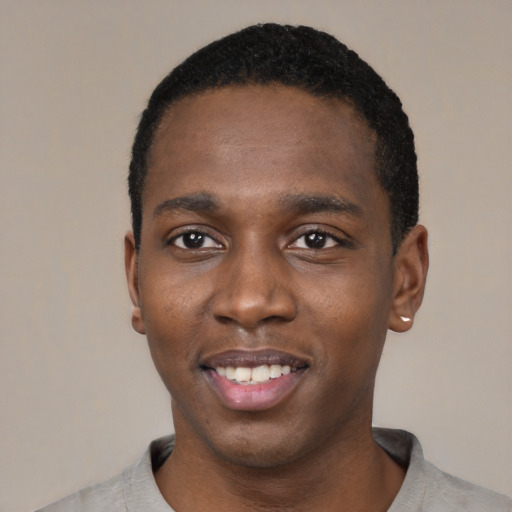 Joyful black young-adult male with short  black hair and brown eyes