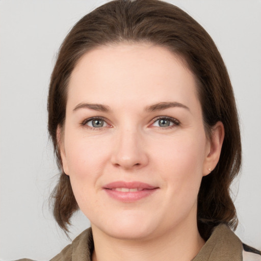 Joyful white young-adult female with medium  brown hair and grey eyes