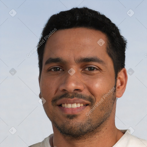 Joyful latino young-adult male with short  black hair and brown eyes