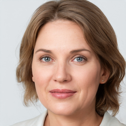 Joyful white adult female with medium  brown hair and blue eyes