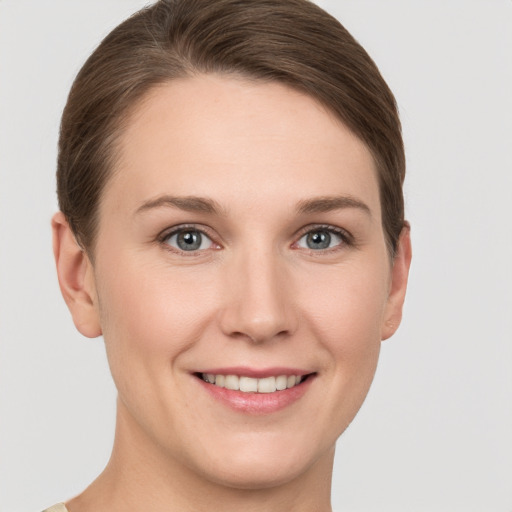 Joyful white young-adult female with short  brown hair and grey eyes