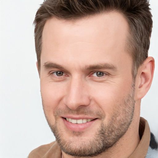 Joyful white young-adult male with short  brown hair and grey eyes