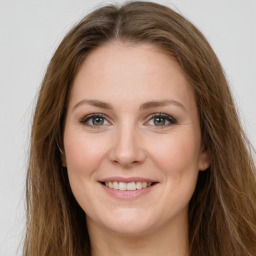 Joyful white young-adult female with long  brown hair and green eyes