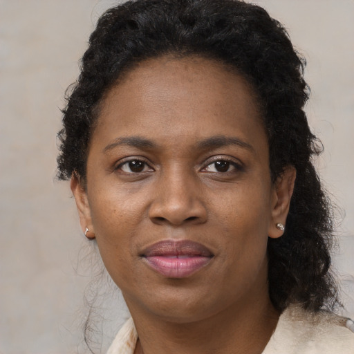 Joyful black adult female with medium  brown hair and brown eyes