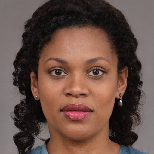 Joyful black young-adult female with long  brown hair and brown eyes