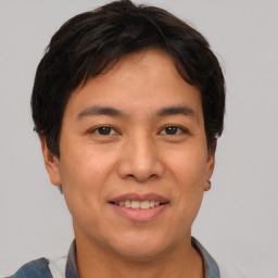 Joyful asian young-adult male with short  brown hair and brown eyes