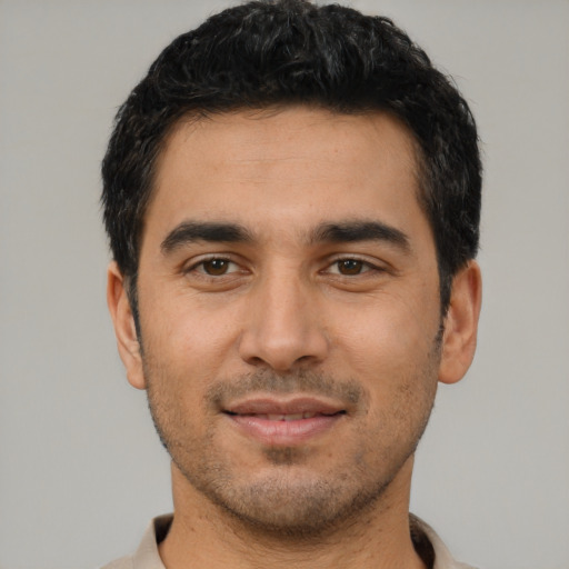 Joyful latino young-adult male with short  black hair and brown eyes