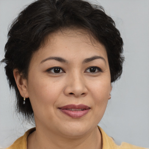 Joyful latino adult female with medium  brown hair and brown eyes