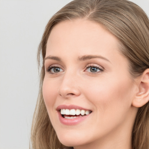 Joyful white young-adult female with long  brown hair and blue eyes