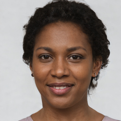 Joyful black young-adult female with short  brown hair and brown eyes