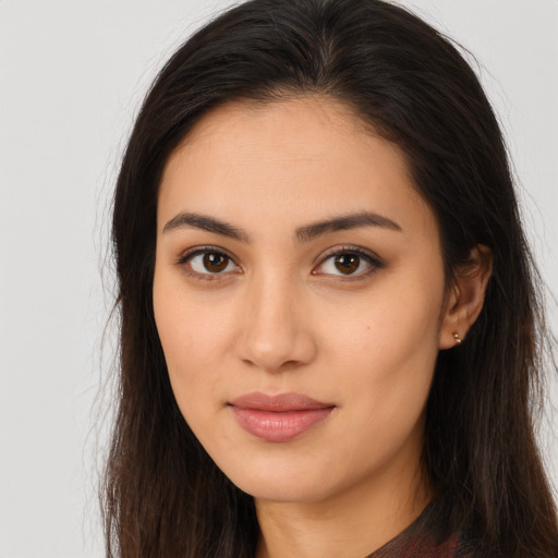 Joyful latino young-adult female with long  brown hair and brown eyes