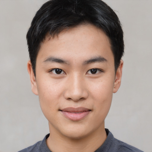 Joyful asian young-adult male with short  black hair and brown eyes