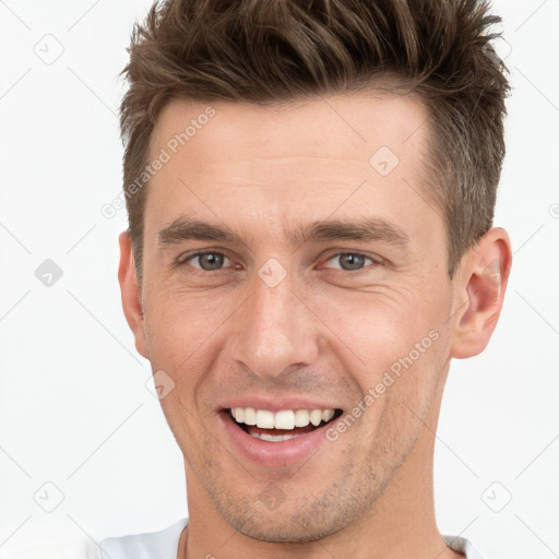 Joyful white young-adult male with short  brown hair and grey eyes