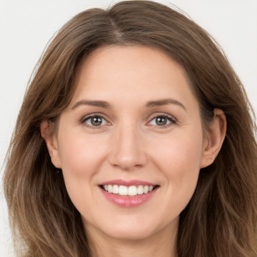 Joyful white young-adult female with long  brown hair and grey eyes