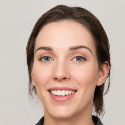 Joyful white young-adult female with medium  brown hair and grey eyes