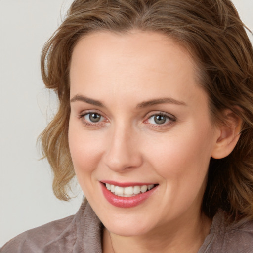 Joyful white young-adult female with long  brown hair and grey eyes