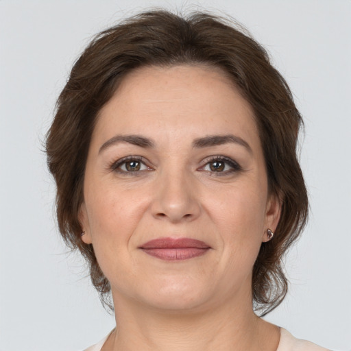 Joyful white adult female with medium  brown hair and brown eyes