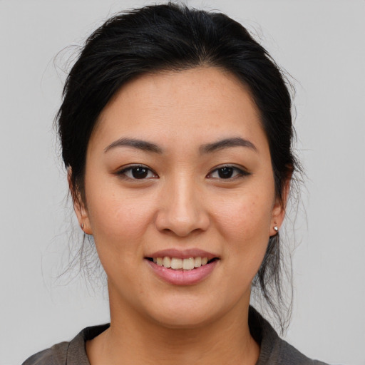 Joyful asian young-adult female with medium  brown hair and brown eyes